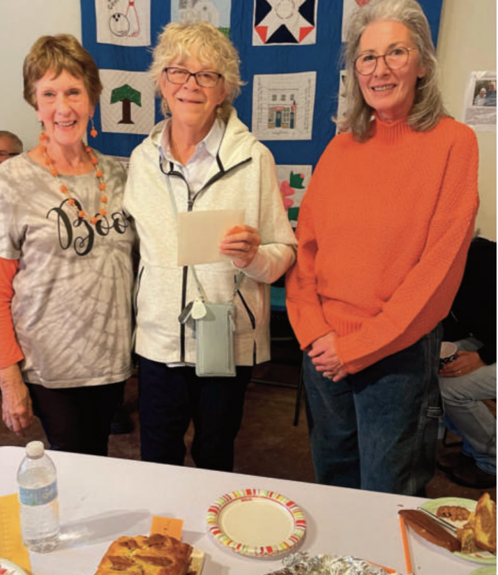 Three older women standing together.