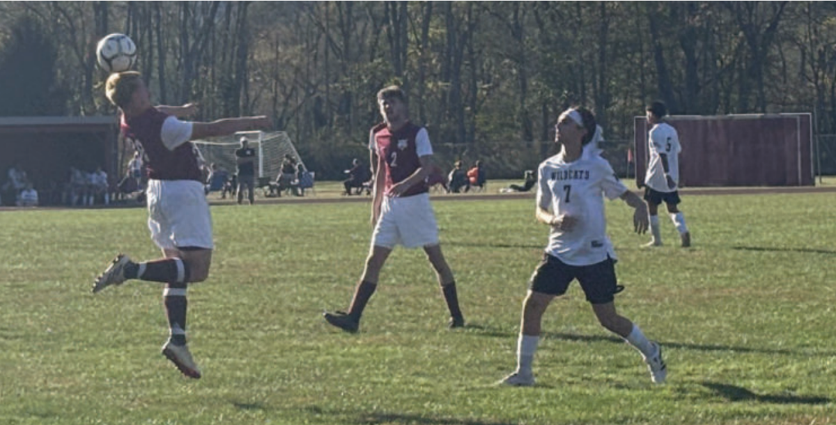 Three people playing soccer.