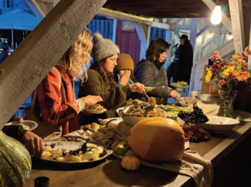 People serving themselves food at a table.