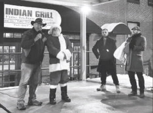 People posing with Santa outside of the Indian Grill.